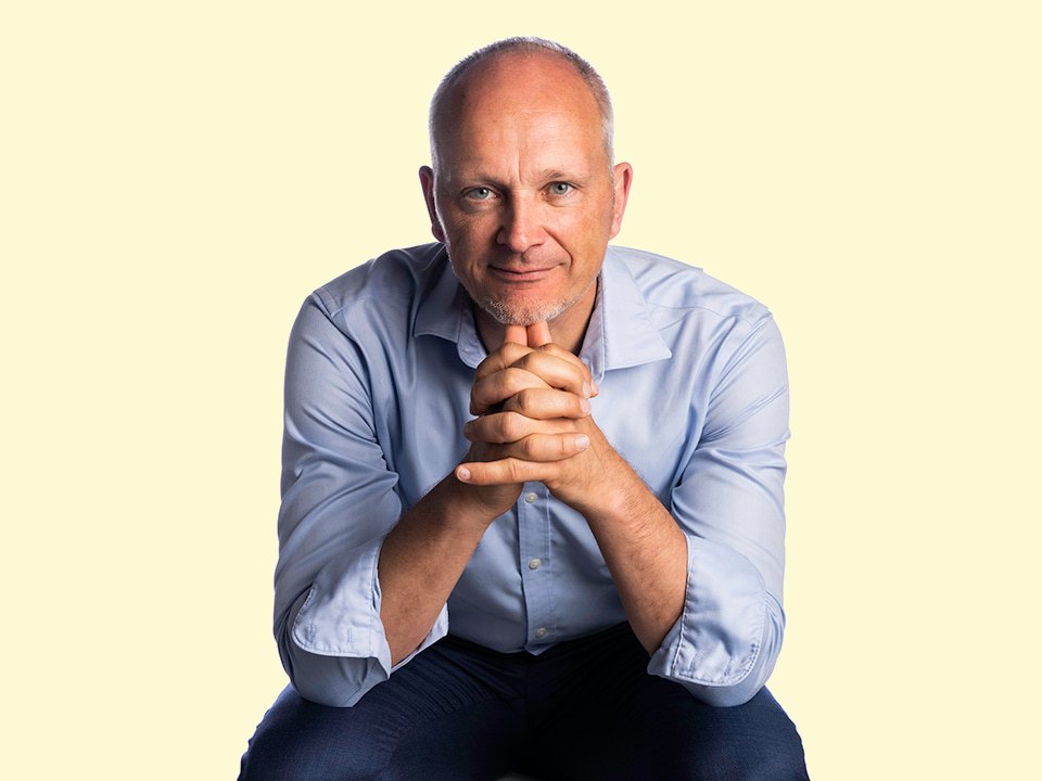 Prof. Dr. Michael Rosemann, sitzend, die Haende unter dem Kinn verschraenkt